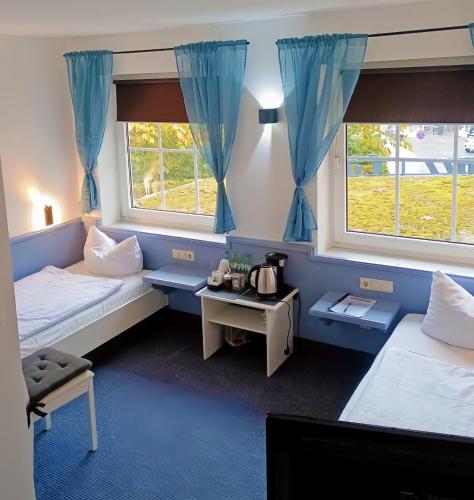 a room with two beds and two windows at Excellent Hotel Hamburg in Hamburg