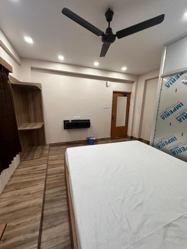 a bedroom with a bed and a ceiling fan at Jagannath Residency And Prasadam in Kolkata