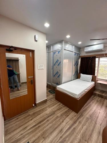 a small room with a bed and a person walking into it at Jagannath Residency And Prasadam in Kolkata