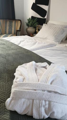 a white blanket is laying on a bed at Hilltop House. in Erdut
