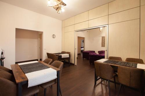 Habitación con mesas, sillas y sala de estar. en Myrtus Guest House Piazza Gramsci, en Cagliari