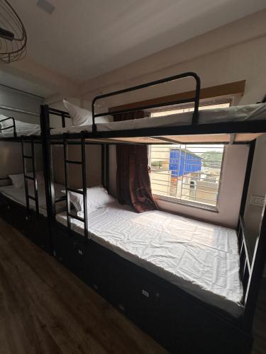 two bunk beds in a room with a window at Jagannath Residency And Prasadam in Kolkata