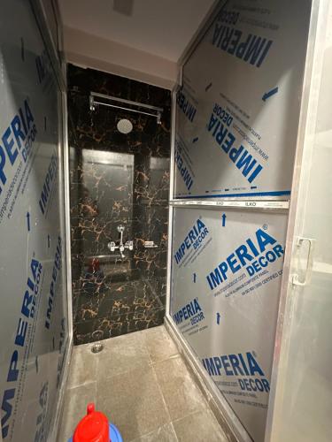 a bathroom with a glass shower with boxes in it at Jagannath Residency And Prasadam in Kolkata