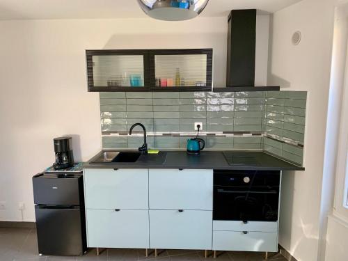 une cuisine avec un évier et un plan de travail dans l'établissement Paris Express studio 5 min on foot to tube station, aux Lilas