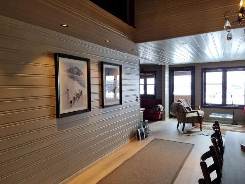 a room with wood paneled walls and windows at Large balcony with panoramic mountain views in Beitostøl