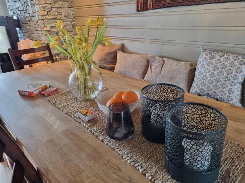 a wooden table with a vase and some oranges on it at Large balcony with panoramic mountain views in Beitostøl