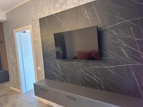 ein Wohnzimmer mit einem Fernseher an der Wand in der Unterkunft Apartament Wave5 in Năvodari