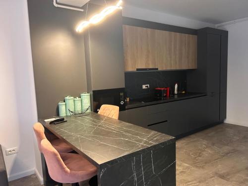 eine Küche mit einer schwarzen Theke und einem Tisch mit Stühlen in der Unterkunft Apartament Wave5 in Năvodari