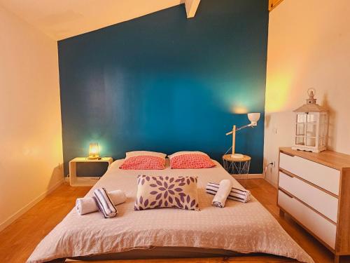 une chambre avec un grand lit avec un mur bleu dans l'établissement Maison chaleureuse à Uzès, à Uzès