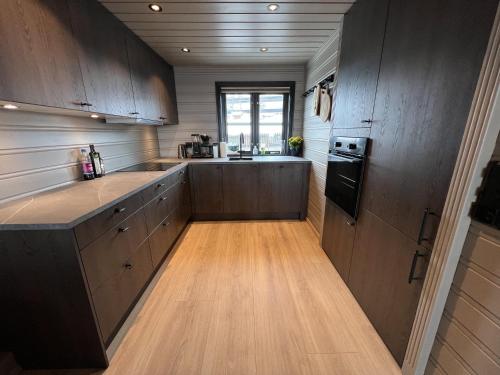 a kitchen with wooden cabinets and a counter top at Large balcony with panoramic mountain views in Beitostøl