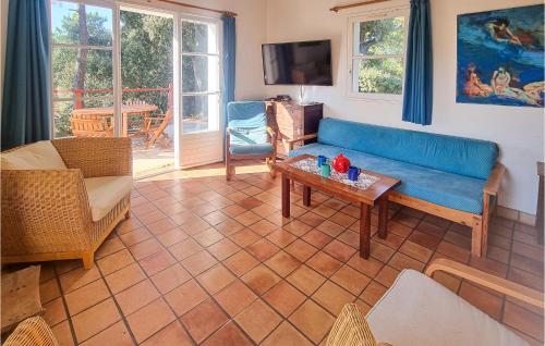 un salon avec un canapé bleu et une table dans l'établissement Gorgeous Home In Saint-Georges-Doléron, à Saint-Georges-dʼOléron