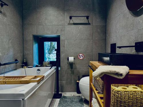 a bathroom with a tub and a toilet and a sink at Spa Villa Mezinska Jacuzzi Sauna in Shiroka Lŭka