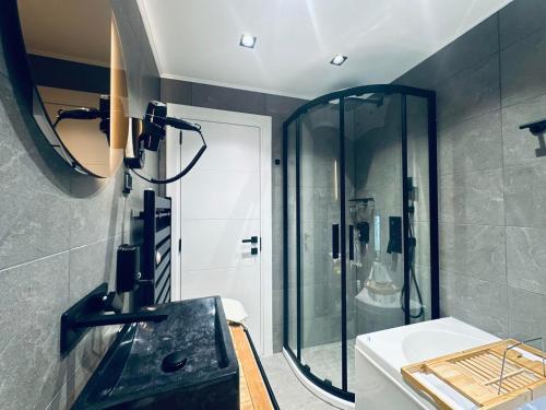 a bathroom with a shower and a sink and a mirror at Spa Villa Mezinska Jacuzzi Sauna in Shiroka Lŭka