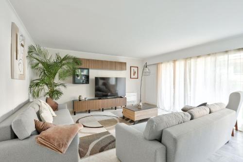 un salon avec un canapé et une télévision dans l'établissement L'Écrin d'Azur – Villa, Cinéma & Plage à 50m, à Cannes