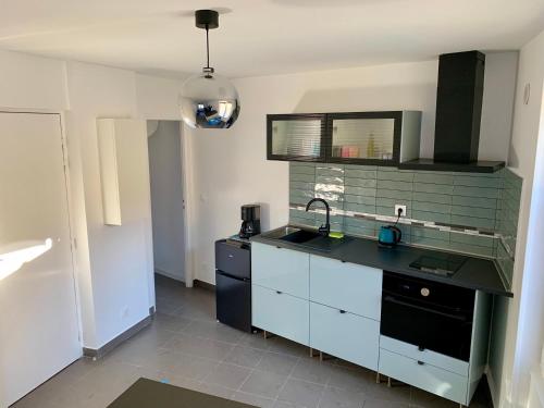 une cuisine avec un évier et un plan de travail dans l'établissement Paris Express studio 5 min on foot to tube station, aux Lilas