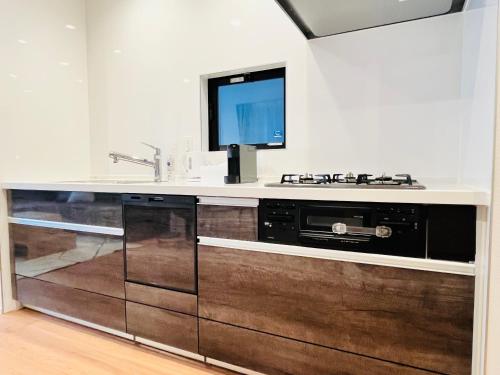 a kitchen with a stove and a tv on a counter at Casa Stella 7 by Liaison in Osaka