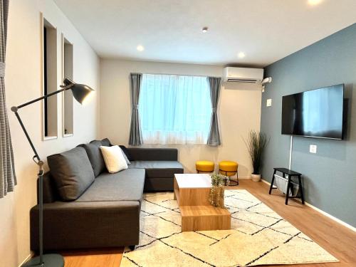 a living room with a couch and a flat screen tv at Casa Stella 7 by Liaison in Osaka