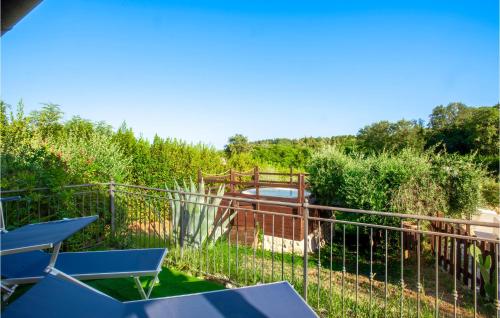 a garden with a fence and some chairs at Cozy Apartment In San Giovanni in Montefiore dellʼAso