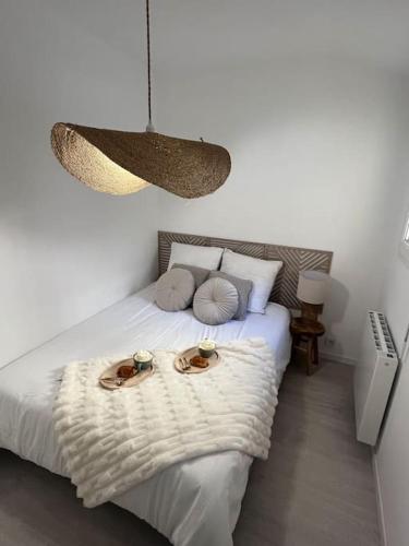 - une chambre dotée d'un lit avec deux assiettes dans l'établissement Charmant T2 tout équipé, au Havre