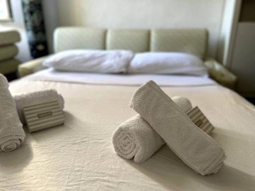 a bed with two rolls of towels on it at Suite Palazzo - Sanremo in Sanremo