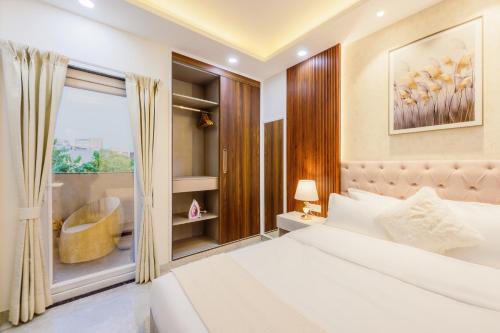 a bedroom with a bed and a window with a chair at Kyomi Service Apartments in Gurgaon