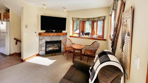 a living room with a couch and a fireplace at Timberline Village #46 home in Sun Peaks