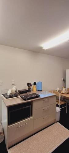a kitchen with a stove and a white wall at Two bedroom homestay with private entrance in convenient location in Auckland