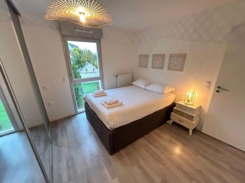 Un dormitorio con una cama y una ventana grande. en Appartement récent tout confort, en Caen