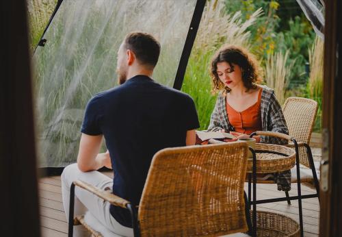 a man and a woman sitting at a table on a porch at Osada Marchowo in Kielno