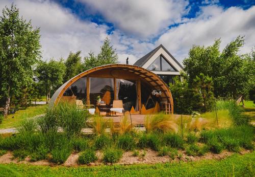 a circular house with a large window in a yard at Osada Marchowo in Kielno