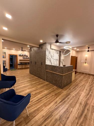 a lobby with a marble counter and blue chairs at Jagannath Residency And Prasadam in Kolkata