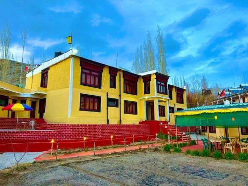 a yellow building with red steps in front at Hotel Ri ~ Rab Leh in Leh