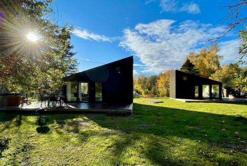 una piccola casa nera su un campo erboso di Paluküla tiny house Kuuse a Paluküla
