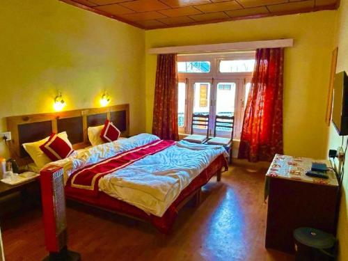 a bedroom with a large bed and a window at Hotel Ri ~ Rab Leh in Leh