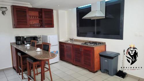 a kitchen with a counter and a table with chairs at Residence Blue Sky in Douala
