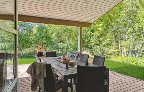 a patio with a table and chairs on a deck at Nice Home In Fjerritslev With Sauna in Fjerritslev