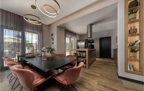 a dining room with a black table and leather chairs at Villa Quercus in Briševo