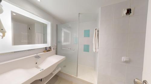 a white bathroom with a sink and a shower at Novotel Lyon Gerland Musée des Confluences in Lyon