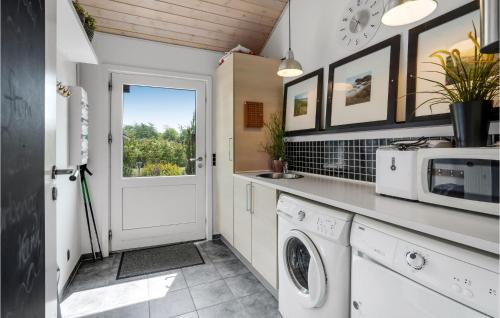 a kitchen with a washing machine and a microwave at Amazing Home In Tarm With Kitchen in Tarm