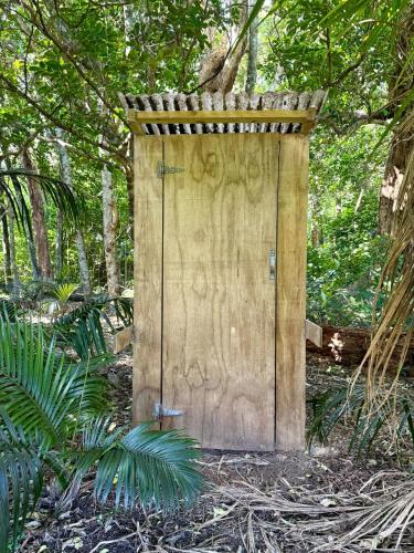 a wooden door in the middle of a forest at The Woolshed, Papa Aroha, Coromandel in Moturua Island