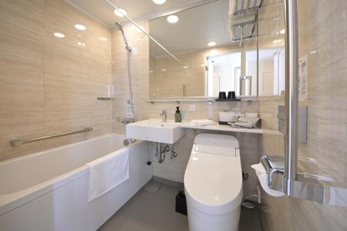 a bathroom with a toilet and a sink and a tub at The Italia Ken in Niigata