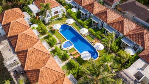 an aerial view of a house with a swimming pool and palm trees at Nomada Villas in Kuta Lombok