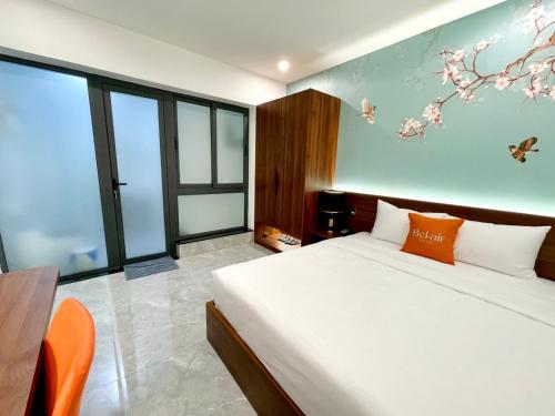 a bedroom with a bed and some windows at Bel-Air Hotel in Quy Nhon