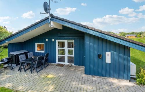 a blue shed with a table and chairs on a patio at Holiday Home Torpet Hovborg Denm in Hovborg
