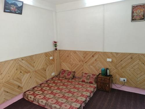 a bedroom with a bed and a wooden wall at aman place homestay river touch in Jibhi