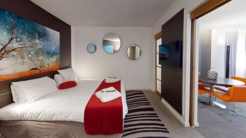 a bedroom with a bed and a table and mirror at Novotel Lyon Gerland Musée des Confluences in Lyon