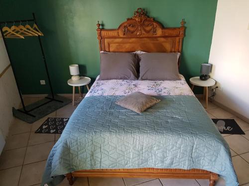 a bed with a wooden headboard in a bedroom at La Petite Maison du Gardien in Sainte-Agnès