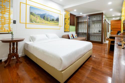 a bedroom with a large white bed and a table at BB Boutique Sathorn in Bangkok