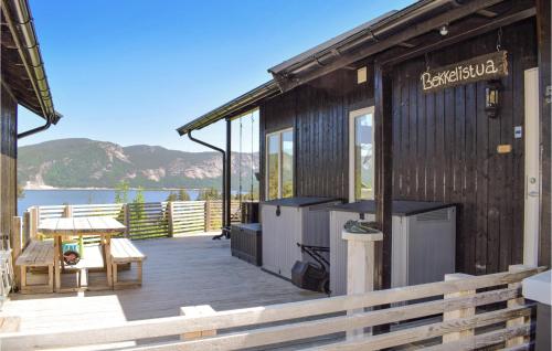 a building with a deck with a table and a bench at Amazing Home In Treungen With Wifi in Treungen
