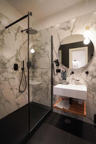 a bathroom with a sink and a shower with a mirror at No Man's Land Guesthouse in Rome